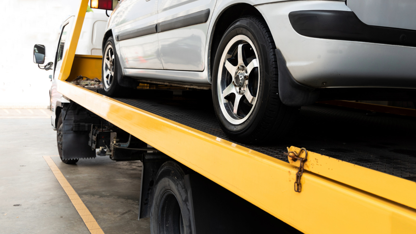 Vehicle securely strapped onto a flatbed tow truck