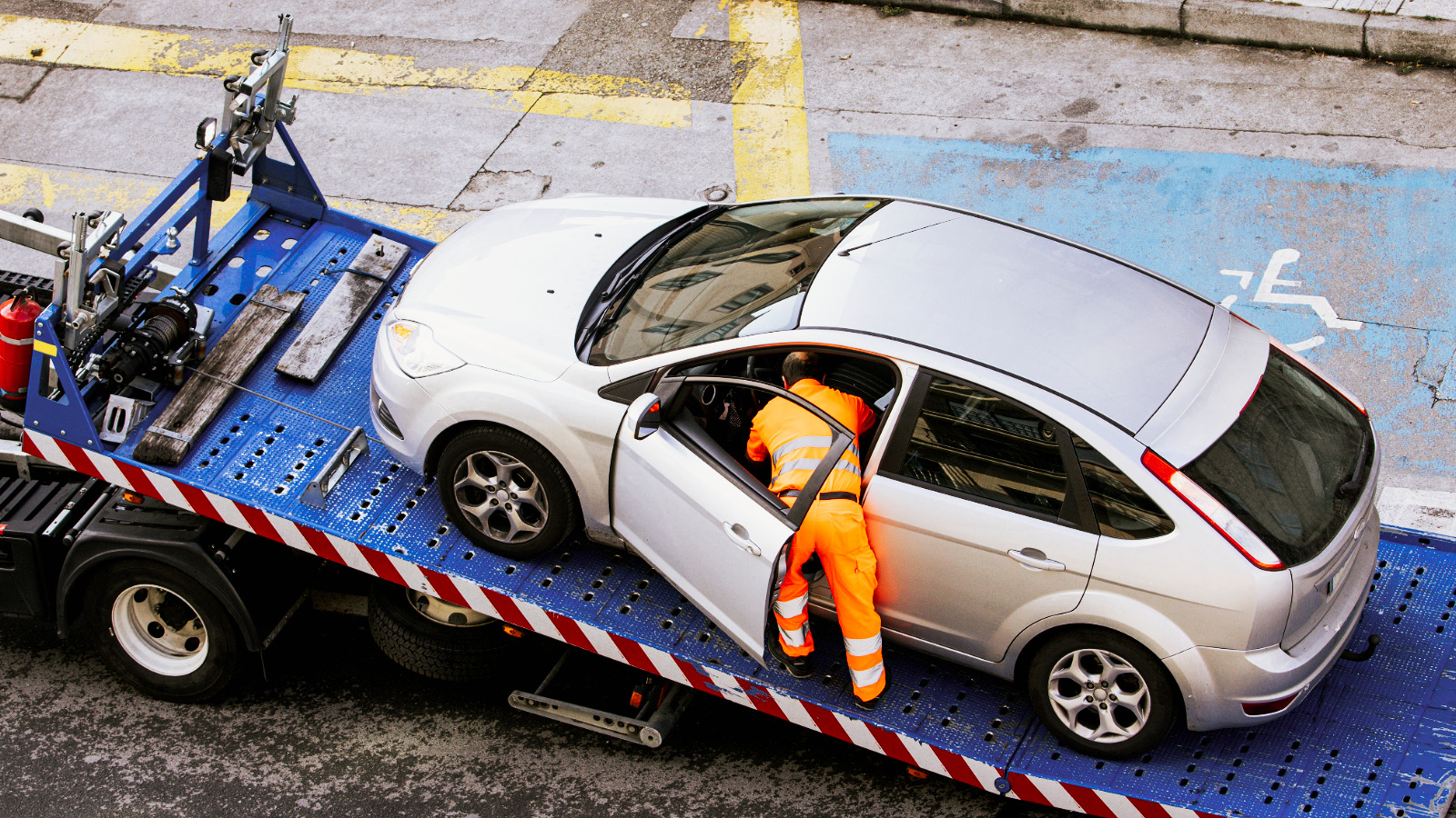 Flatbed tow truck transporting a luxury car